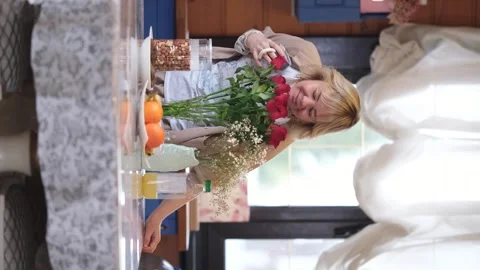 Cute blonde in the kitchen, drinking morning coffee. She holds a mug with a hot Stock Footage 288408142