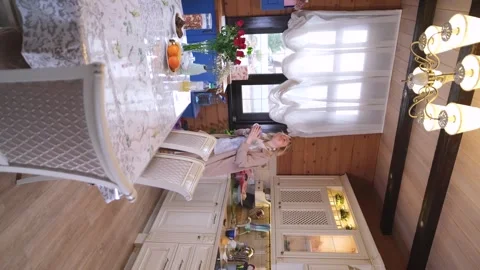 Cute blonde in the kitchen, drinking morning coffee. She holds a mug with a hot Stock-Footage 305854326
