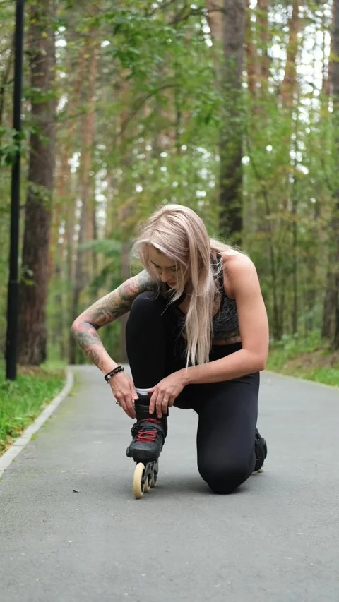 Cute blonde puts on roller skates. She feels free and light while roller skating Stock-Footage 307970382