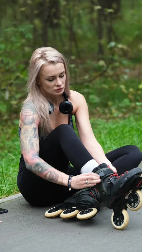 Cute blonde puts on roller skates. She feels free and light while roller skating Stock Footage 307970485