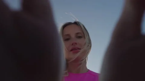 Cute Blonde smiling at sunset on the beach by the ocean in a pink to Stock Footage 170158520