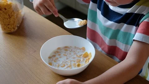 Cute boy 4 years old having breakfast cornflakes with milk at the table at home. Stock Footage 111246866