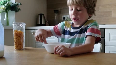 Cute boy 4 years old having breakfast cornflakes with milk at the table at home. 스톡 동영상 111247548
