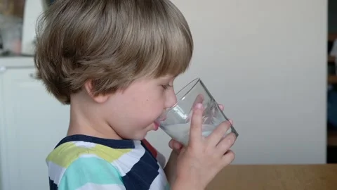 Cute boy 4 years old drinking milk at the table at home. Stock Footage 111249655