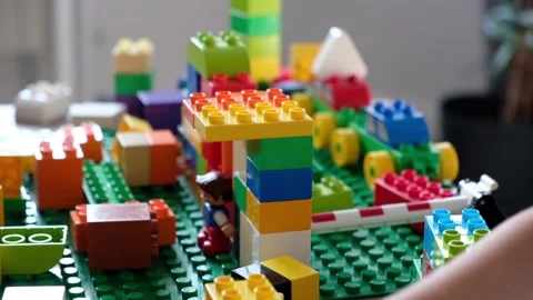 Cute boy 4 years old playing with colorful plastic toy bricks at the table at Stock Footage 111367326