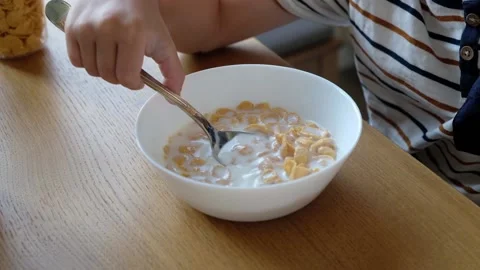 Cute boy 4 years old having breakfast cornflakes with milk at the table at home. 스톡 동영상 111405671