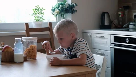 Cute boy 4 years old having breakfast cornflakes with milk at the table at home. Stock Footage 111405734