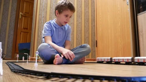 Cute boy 6-7 years old playing with children's railroad Stock Footage 147346782