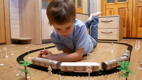 Cute boy 6-7 years old playing at home with toy railroad Video stock 166548458