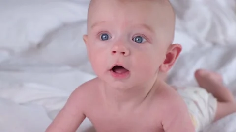 Cute boy 6 months old or half a year old on a light background Stock Footage 235338462
