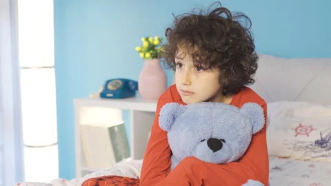 Cute boy in bed looking around fearfully. Fear of the dark. Video stock 227667413