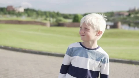 Cute boy blond walks in the park in the summer Stock Footage 111212976