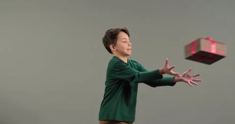 Cute boy catch and throw gifts isolated on grey background Stock Footage 286247584