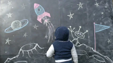Cute Boy With A Chalkboard Drawing of Space Stock Footage 34496661