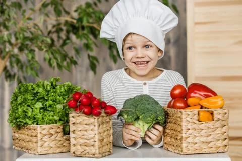 Cute boy in chef uniform with vegetables. Vegetarian. Healthy food Stock Photos