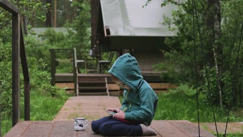Cute boy child playing with tablet pc on forest background. Computer Games Stock-Footage 133389295