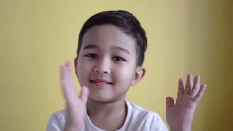 Cute boy clapping his hands on colour background Stock Footage 195037771