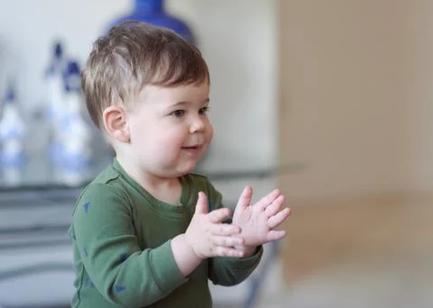 Cute boy clapping his hands at home Stock Photos