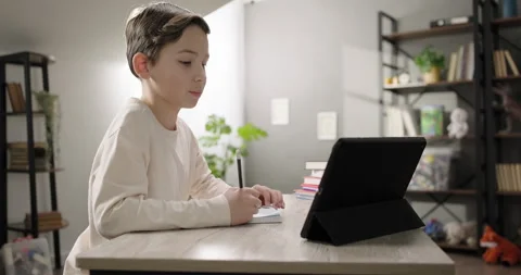 Cute boy communicating with teacher by webcam conference call on digital tablet Stock Footage 290331221