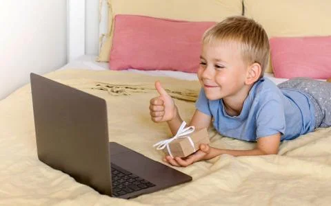Cute boy congratulates via video link and gives a gift. Foto stock