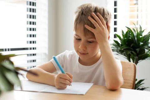 Cute boy doing school homework at home. Distance education. Online education. Foto stock