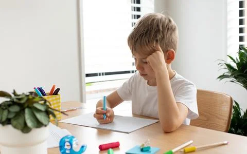 Cute boy doing school homework at home. Distance education. Online education. Foto stock