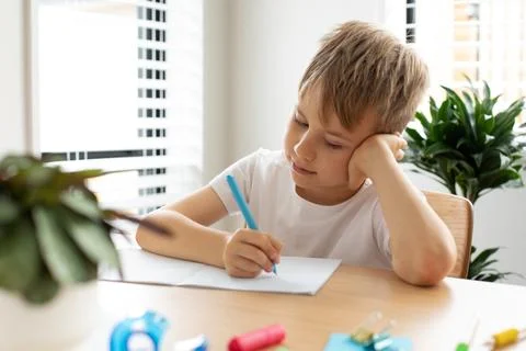 Cute boy doing school homework at home. Distance education. Online education. Fotos de archivo