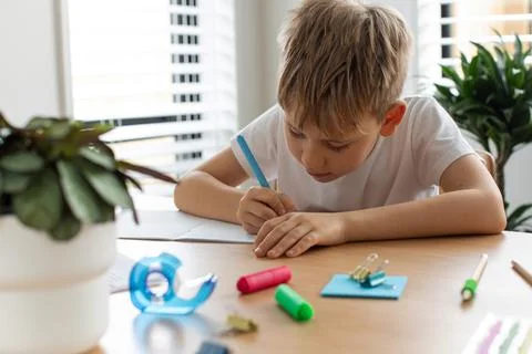 Cute boy doing school homework at home. Distance education. Online education. Foto stock