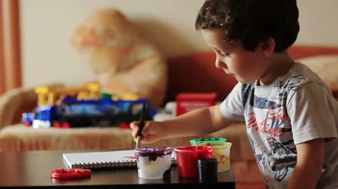Cute boy draws paints at the table Stock Footage 28298377