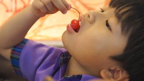 Cute a boy eating cherry fruit in the restaurant Stock Footage 89968209