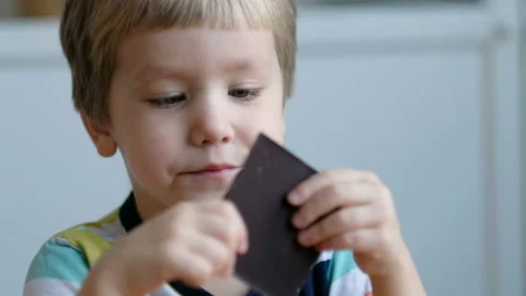 Cute boy eating chocolate, close up Stock Footage 102704196