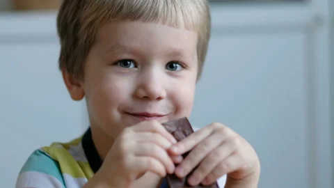 Cute boy eating chocolate, close up Stock Footage 102705264