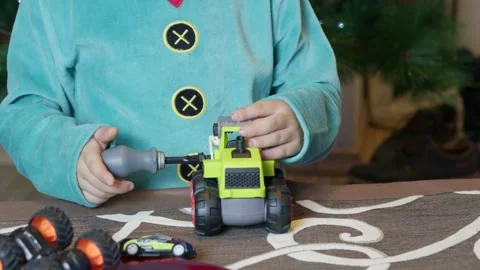 Cute boy elf assembling toys for kids in front of Christmas tree. Stock Footage 286062053
