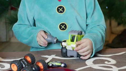 Cute boy elf assembling toys for kids in front of Christmas tree. Stock Footage 289785733