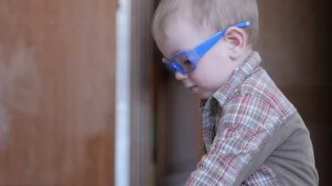 Cute boy in funny glasses draws with both hands on paper at home Stock Footage 88961135