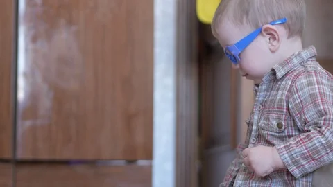 Cute boy in funny glasses draws with both hands on paper at home Stock Footage 88961524