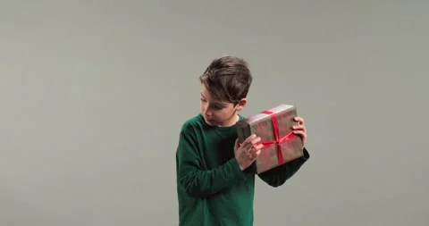Cute boy with a gift box isolated on a grey background Stock Footage 286247928