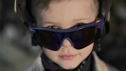 Cute boy with goggles poses for camera on blurred background Stock Footage 152714190