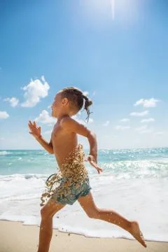 Cute boy is having fun on the beach Stock Photos