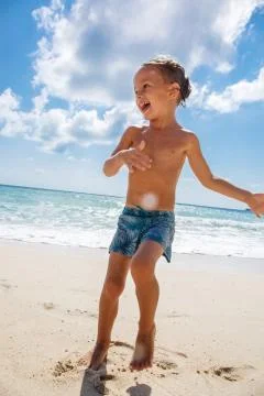 Cute boy is having fun on the beach Stock Photos