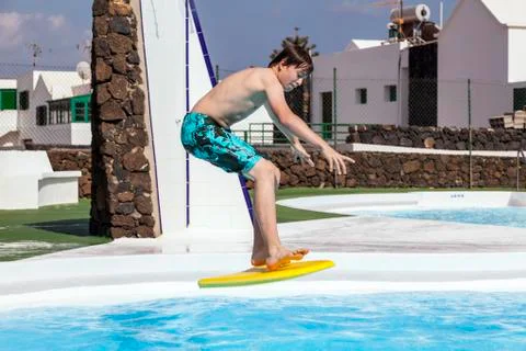 Cute boy jumping in the pool Stock Photos