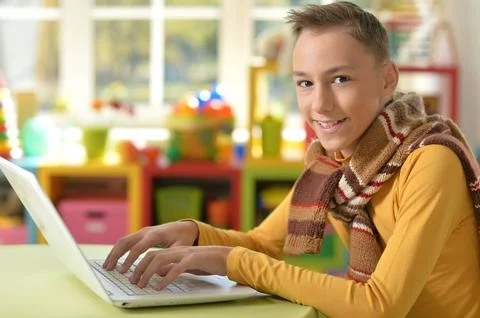 Cute boy with laptop at the table Stock Photos