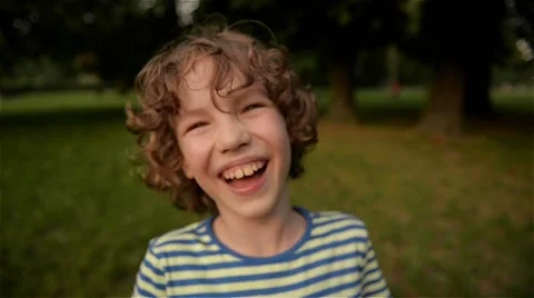 Cute boy laughing in the park, close-up, slow motion Stock Footage 63901667
