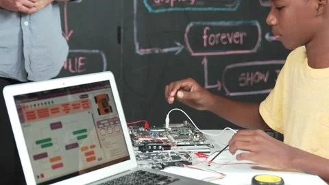 Cute boy learning to use electronic tool while laptop display code. Edification Stock Footage 277182320