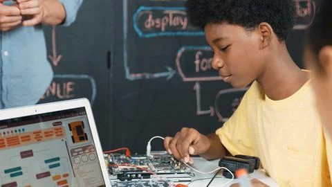 Cute boy learning to use electronic tool while laptop display code. Edification. Foto stock