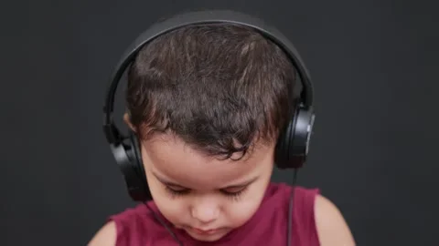 Cute boy loking down with headphone he is watching mobile phone Stock Footage 160548591