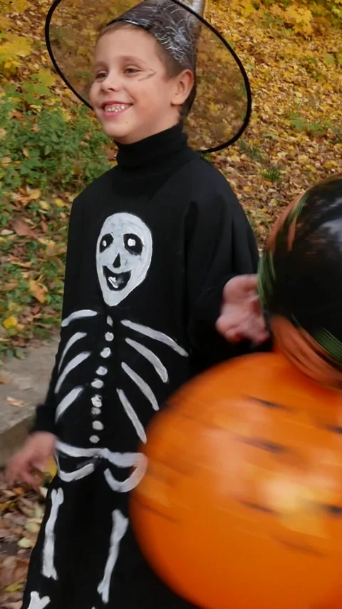 A cute boy in a long black suit walks along the path. Halloween. Stock Footage 317849467