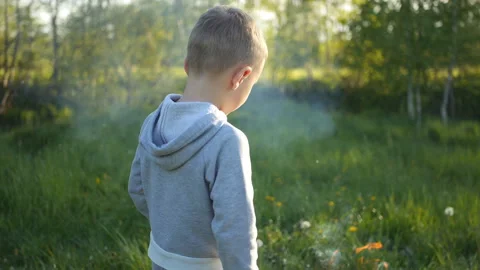 Cute boy looking at the bonfire and dancing at sunset back view Stock Footage 131744780