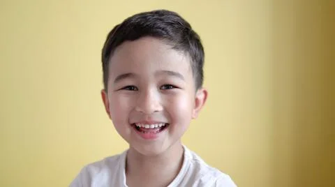 Cute boy looking at camera and laughing on colour background Stock Photos