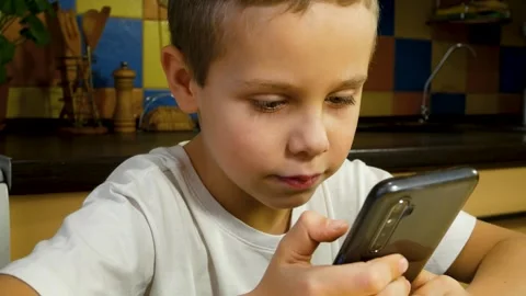 Cute boy looking at smartphone screen and talking. Communication with the help Video stock 254498073